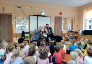 Pan Maciej wraz z dziewczynką prezentują guziki.