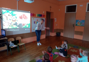 Przedszkolaki trzymają swoje kropki nad głowami.