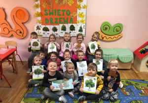 Dzieci z grupy „Promyczki” pokazują zdjęcia różnych drzew.