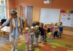 Dzieci wraz z nauczycielką tworzą pociąg.
