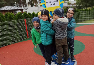 Chłopcy stoją z transparentem - Przedszkole Nr 20 na placu zabaw.