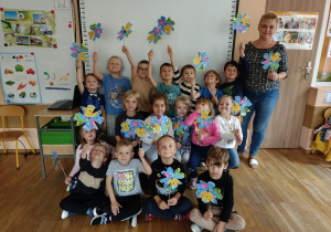 Pamiątkowe zdjęcie dzieci z papierowymi wiatraczkami