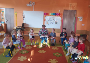 Nauczycielka pokazuje dzieciom jak należy głaskać psa.