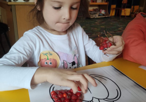 „Jarzębinowa dynia”- dziewczynka wykonuje pracę plastyczną.