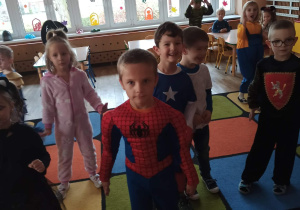 Dzieci w bajkowych strojach tańczą przy muzyce.