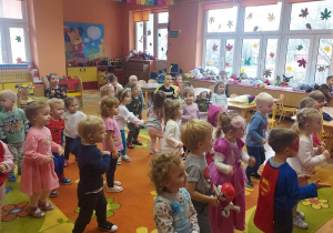 Przedszkolaki w bajkowych strojach tańczą w rytm muzyki.