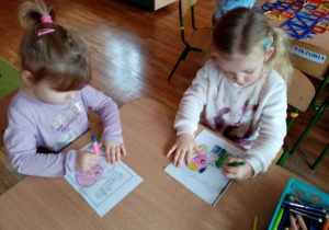 Dziewczynki kolorują bajkowe postacie.