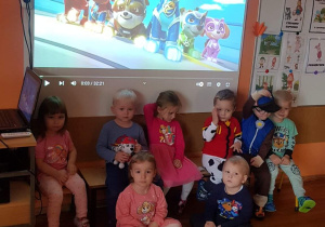 Dzieci w strojach związanych z psim patrolem na tle bajki „Psi patrol”.