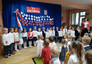Przedszkolaki wraz z nauczycielkami śpiewają hymn.