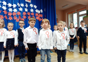 Trzej chłopcy recytują wiersz.