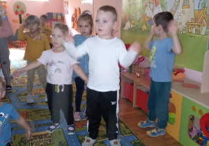 Przedszkolaki naśladują pokazane na tablicy zwierzęta.