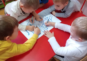 Chłopcy kolorują obrazek przedstawiający słonia.