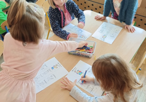 Dzieci kolorują obrazki.