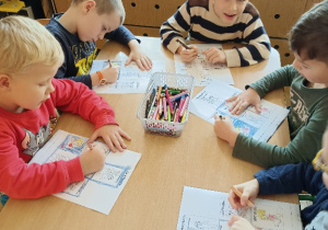 Dzieci kolorują obrazki.