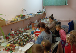 Dzieci obserwują proces ozdabiania bombek