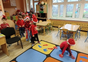 Dzieci idą po śladach stóp i rąk.