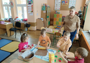 Chłopiec wałkuje ciasto na stolnicy