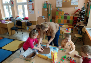 Pani z dziewczynką foremkami wyciskają pierniki