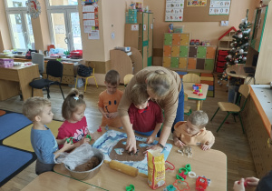 Pani z chłopcem wyciskają w cieście foremką pierniki