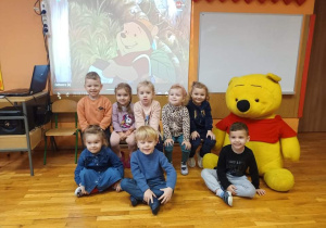 Pamiątkowe zdjęcie dzieci z grupy „Gwiazdeczki” z pluszowym Kubusiem Puchatkiem.