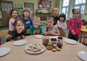 Dzieci oglądają „Kubusiowe” przysmaki- różne rodzaje miodu.