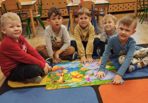 Chłopcy pokazują ułożone przez siebie puzzle