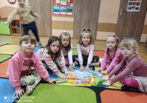 Dziewczynki pokazują ułożone przez siebie puzzle