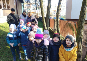 Dzieci z grupy „Chmurki” obserwują karmnik w ogrodzie.