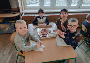 Dzieci jedzą pizzę