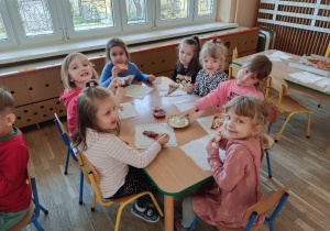 Dzieci jedzą pizzę