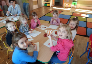 Dzieci jedzą pizzę