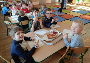 Dzieci jedzą pizzę