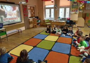 Dzieci oglądają film edukacyjny o kotach