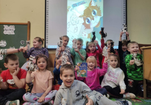 Zdjęcie pamiątkowe dzieci z pracami plastycznymi - kotkami