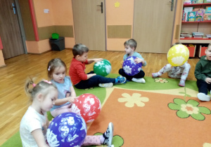 Przedszkolaki oglądają balony- rozpoznają narysowane na nich dinozaury.