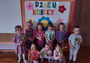 Pamiątkowe zdjęcie dziewczynek z grupy Gwiazdeczki z otrzymanymi od chłopców tulipanami.
