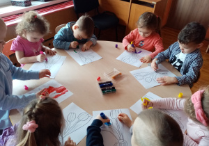 Dzieci kolorują obrazki „Kwiaty dla wszystkich kobiet”.