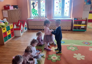 Chłopcy wręczają dziewczynkom upominki.