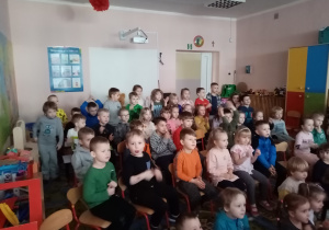 Przedszkolaki oglądają z zaciekawieniem teatrzyk.