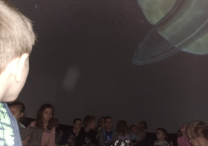 Dzieci w mobilnym planetarium obserwują inne planety