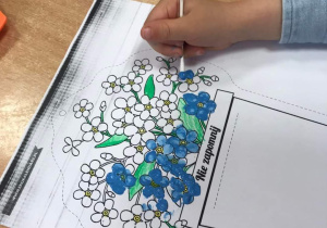 Dzieci robią pracę plastyczną "Niezapominajki"