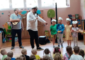 Zaproszone na scenę dzieci otrzymują stroje marynarzy oraz owoce.