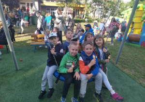 Grupa dzieci siedzi na huśtawce - bocianie gniazdo i je lody