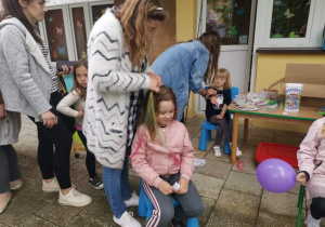 Pani plecie warkoczyk dziewczynce