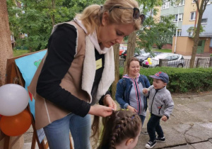 Pani zaplata warkocze dziewczynce