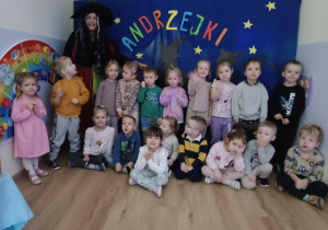 Zdjęcie grupowe dzieci na tle z napisem Andrzejki.