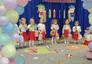 Grupa dzieci stoi na tle dekoracji Pasowania na przedszkolaka.