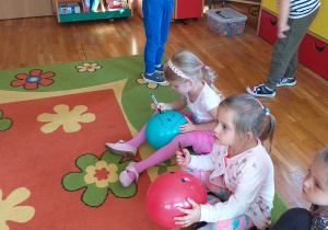 Dzieci rysujące buźki na nadmuchanych balonach