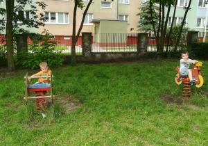 Dwóch chłopców bujających się na ogrodowych sprężynowcach