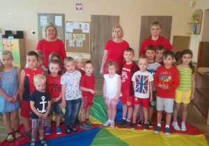 Panie z dziećmi stoją na kolorze czerwonym chusty animacyjnej